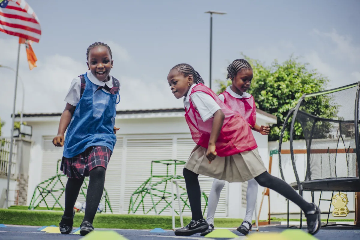 Students running an agility drill outdoors.