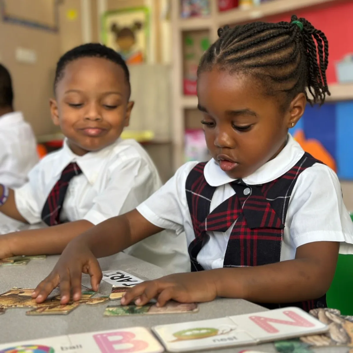 Two students fitting puzzle pieces together.