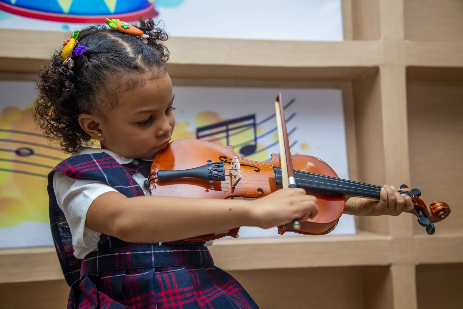 A young student practising with a toy violin.