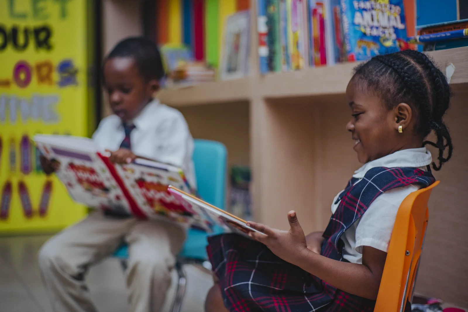 Two students reading picture books together.